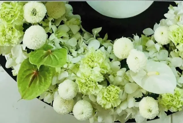 ครึ่งล่างของวงดำ ไฮเดรนเยียขาว ปอมปอมขาว คาร์เนชั่นเขียว และหน้าวัวเขียวอ่อน